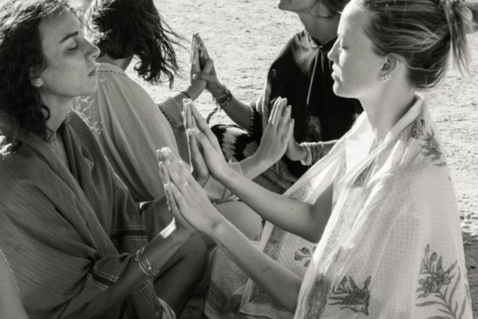 Women sitting in a circle with their palms pressed together