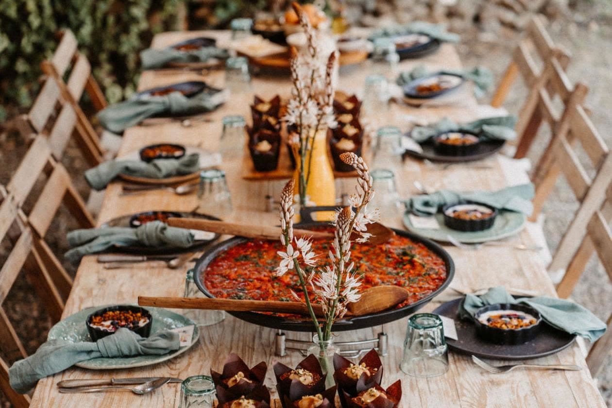 A long table set for a shared meal outdoors