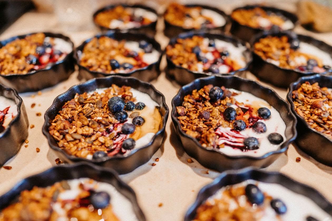 Bowls of yoghurt topped with granola and blueberries