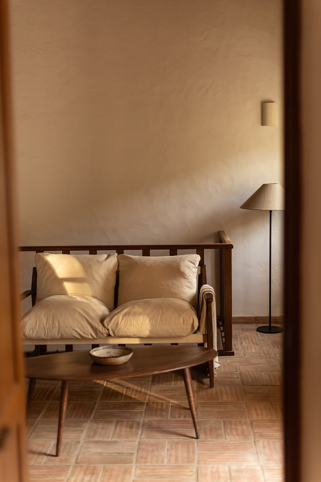 A sofa with cushions and a low table in a warm-toned lounge