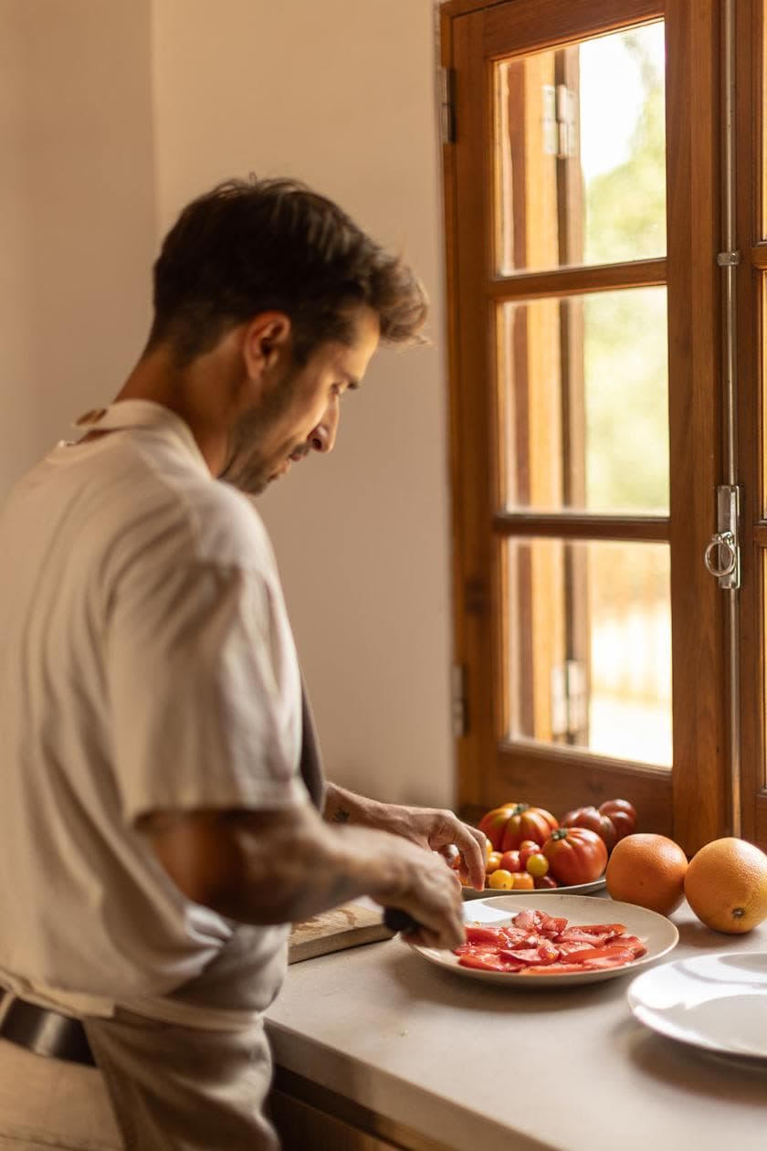 The chef slicing tomatoes in the kitchen