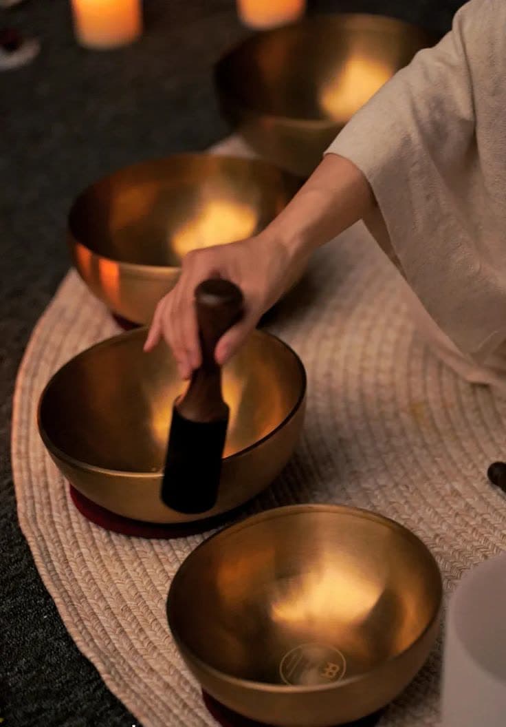 Hands playing brass singing bowls